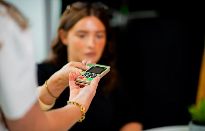 Une femme paye avec sa carte sur un PAX D177